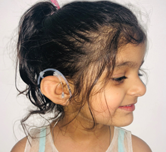 Girl wearing a cochlear implant processor